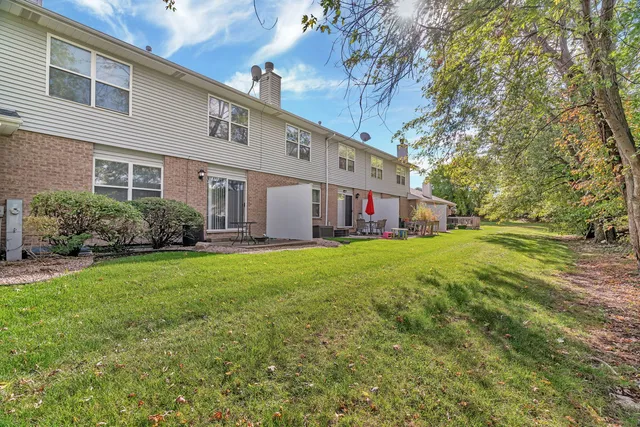 front view of a brick house with a yard
