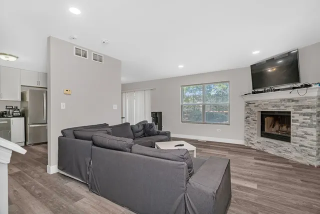 a living room with furniture a fireplace and a flat screen tv