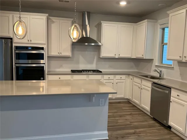 a kitchen with granite countertop a stove and cabinets