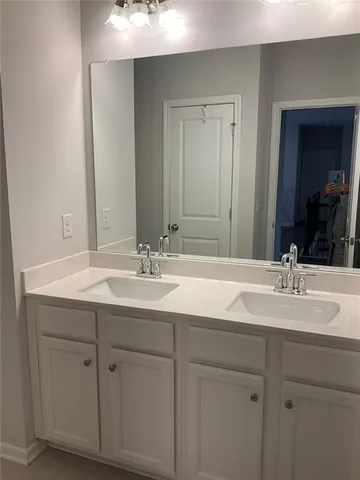 a bathroom with double sink and a mirror