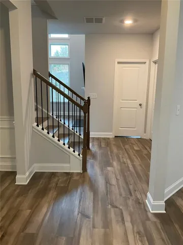 a view of a hallway with wooden floor and stairs