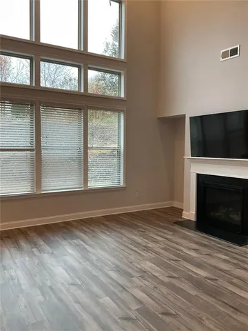 a view of an empty room with a window and fireplace