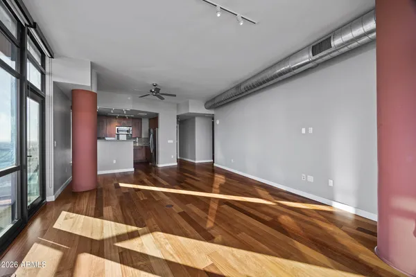 a living room with stainless steel appliances furniture a rug and a large window