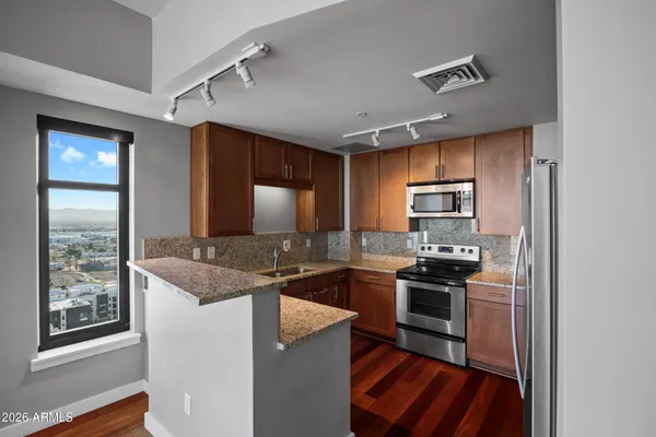 a kitchen with stainless steel appliances granite countertop a stove top oven a sink and dishwasher