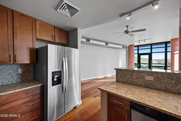 a kitchen with granite countertop a refrigerator and a sink