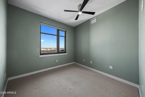 an empty room with windows and ceiling fan