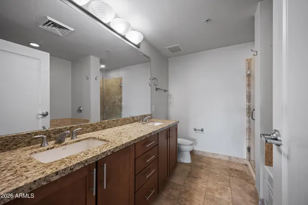 a bathroom with a granite countertop sink toilet and shower