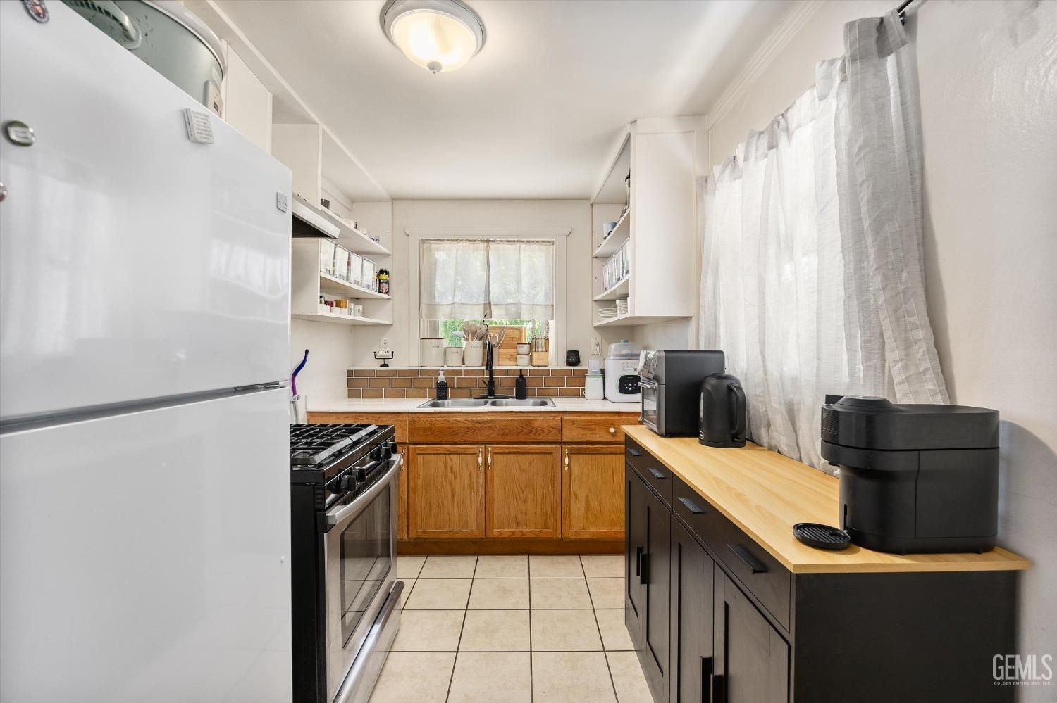 Undisclosed Address Bakersfield, CA 93304 - Photo 14 of 25 a kitchen with stainless steel appliances granite countertop a sink stove and refrigerator
