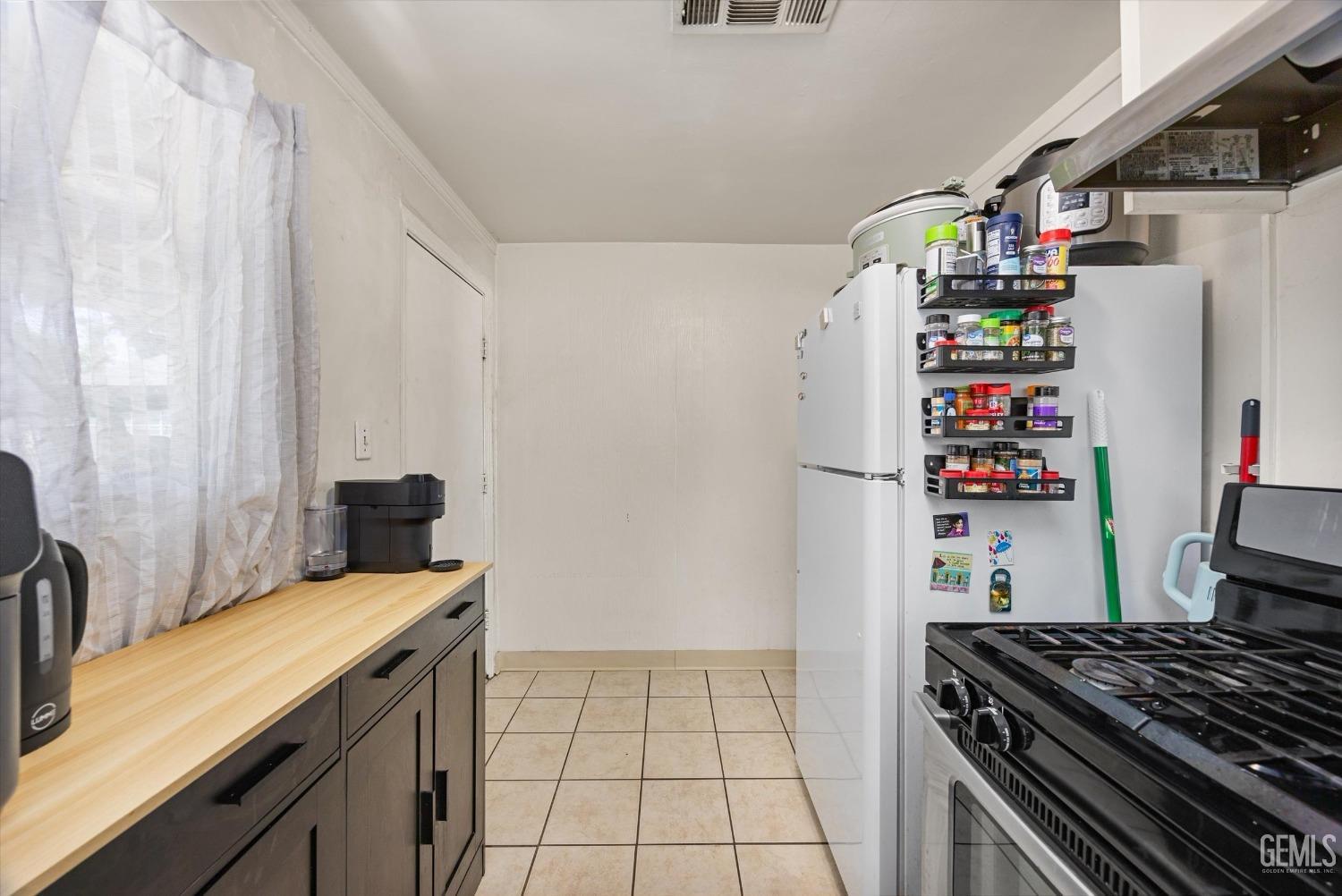 Undisclosed Address Bakersfield, CA 93304 - Photo 17 of 25 a kitchen with a refrigerator and a stove