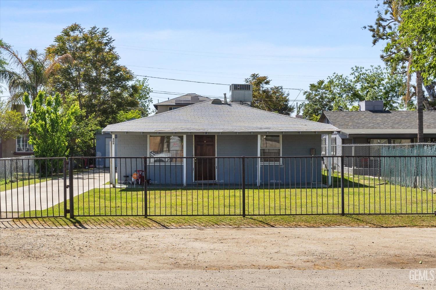 Undisclosed Address Bakersfield, CA 93304 - Photo 3 of 25 a view of a house with a small yard and a large tree front of it