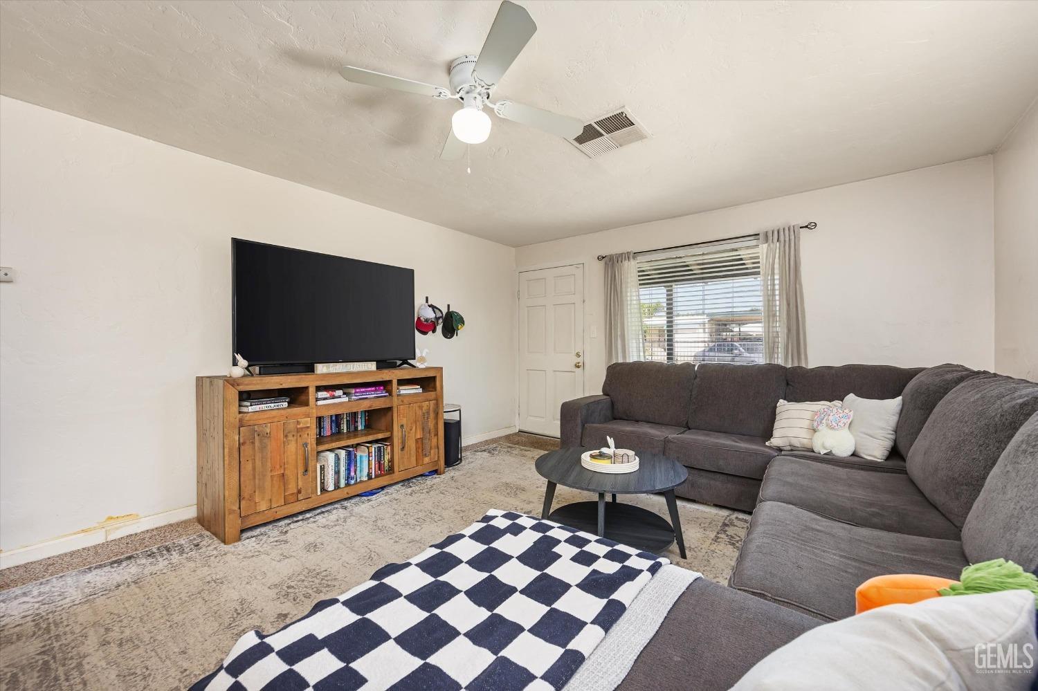 Undisclosed Address Bakersfield, CA 93304 - Photo 10 of 25 a living room with furniture and a flat screen tv