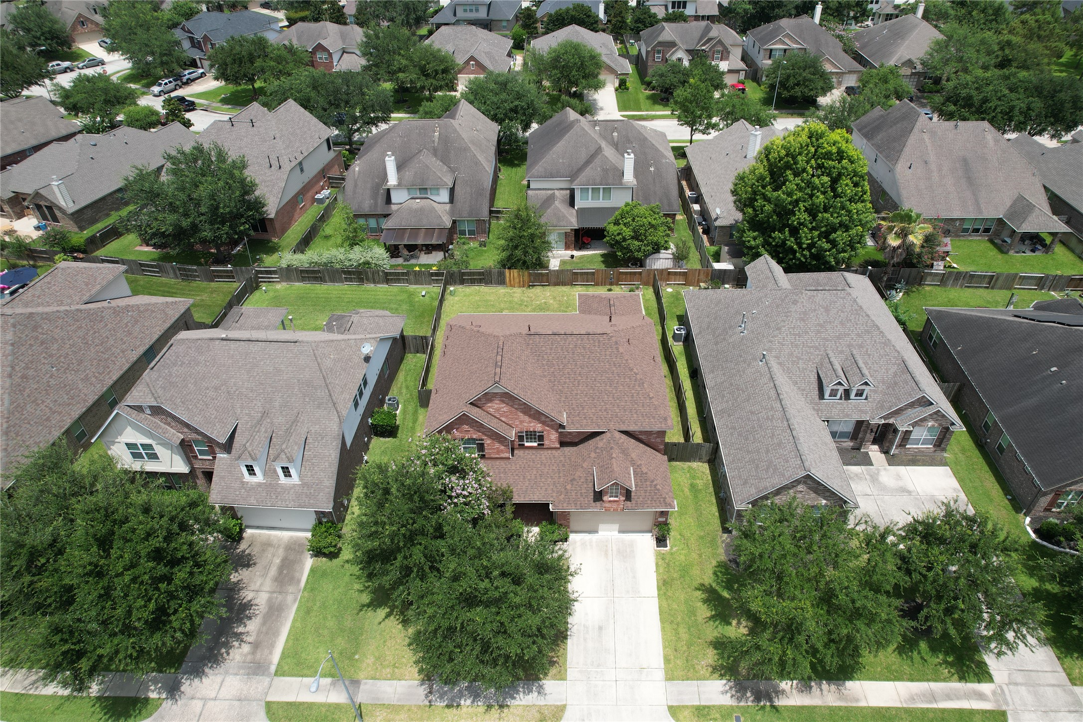 17402 Rainer Valley Lane Humble, TX 77346 - Photo 29 of 33 This aerial photo showcases a suburban neighborhood with well-maintained, single-family homes. Each house features a driveway, manicured lawns, and is surrounded by lush trees. The area appears peaceful and family-friendly, with a consistent architectural style.