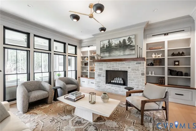 a living room with furniture a fireplace and a floor to ceiling window