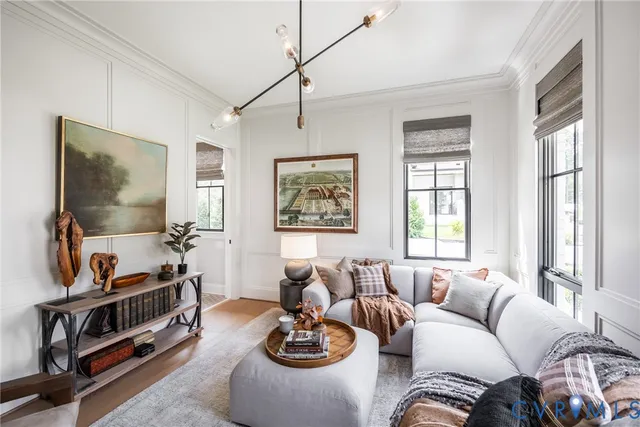 a living room with furniture a flat screen tv and a window