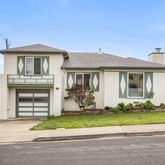 a front view of a house with a garden and yard