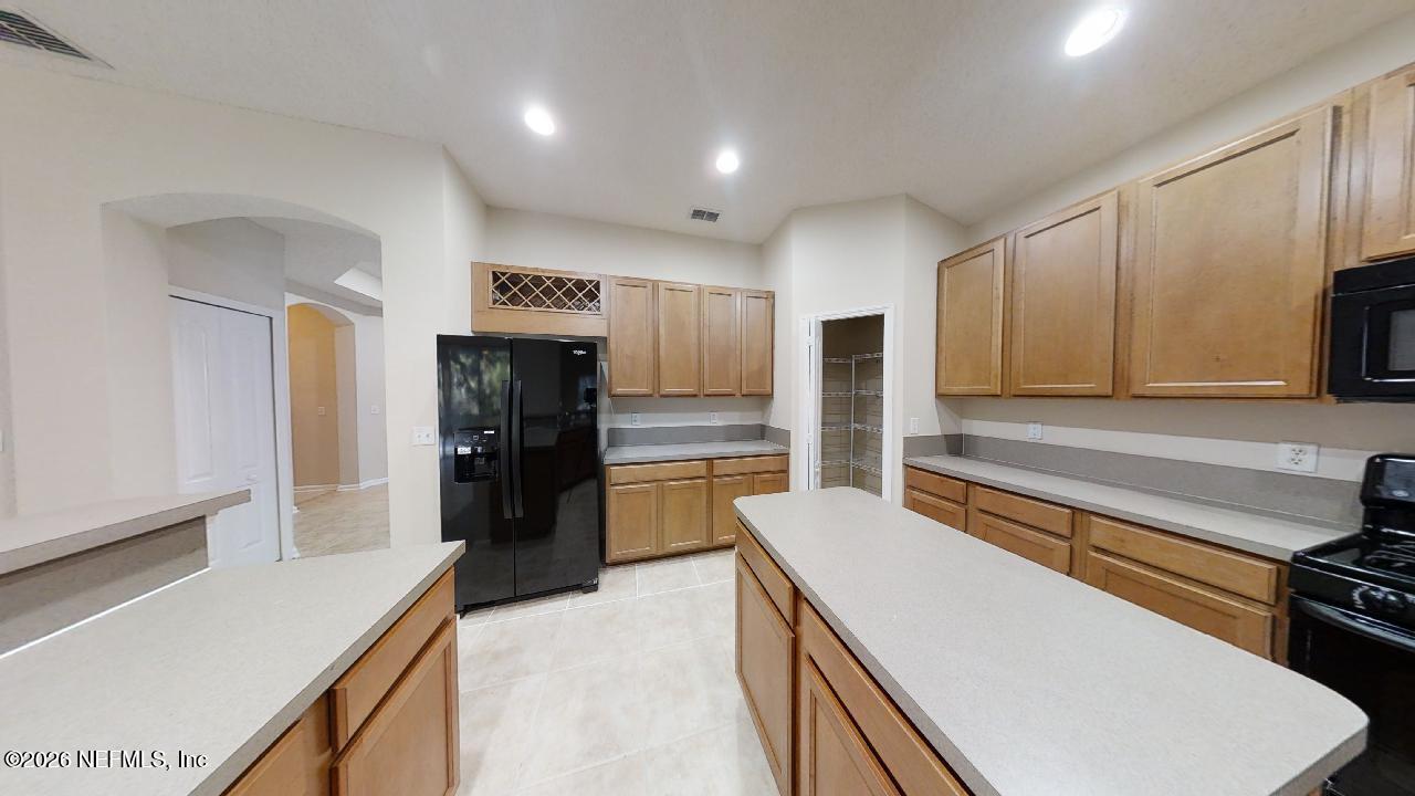 14454 Millhopper Road Jacksonville, FL 32258 - Photo 4 of 44 a kitchen with a refrigerator and a stove top oven