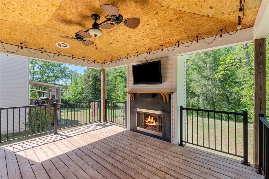 1237 Madden Bridge Road Central, SC 29630 - Photo 22 of 46 This spacious outdoor deck features a cozy fireplace and overlooks a serene, verdant landscape.