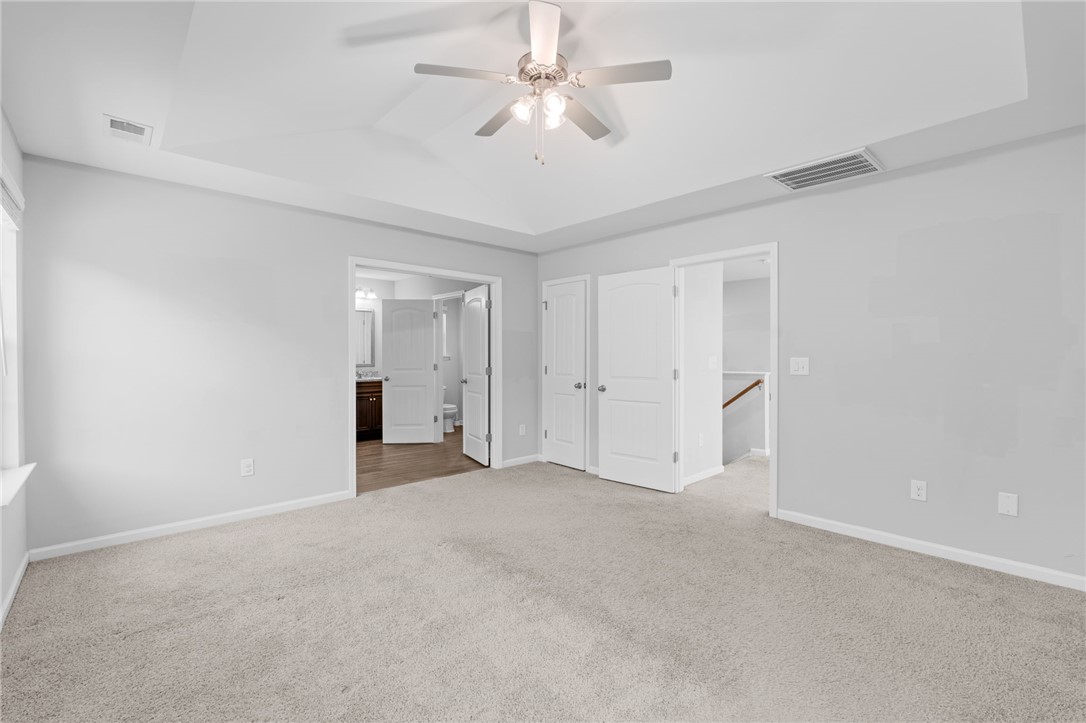 1237 Madden Bridge Road Central, SC 29630 - Photo 31 of 46 This primary bedroom offers plush carpeting, a ceiling fan, and convenient access to a private bathroom.