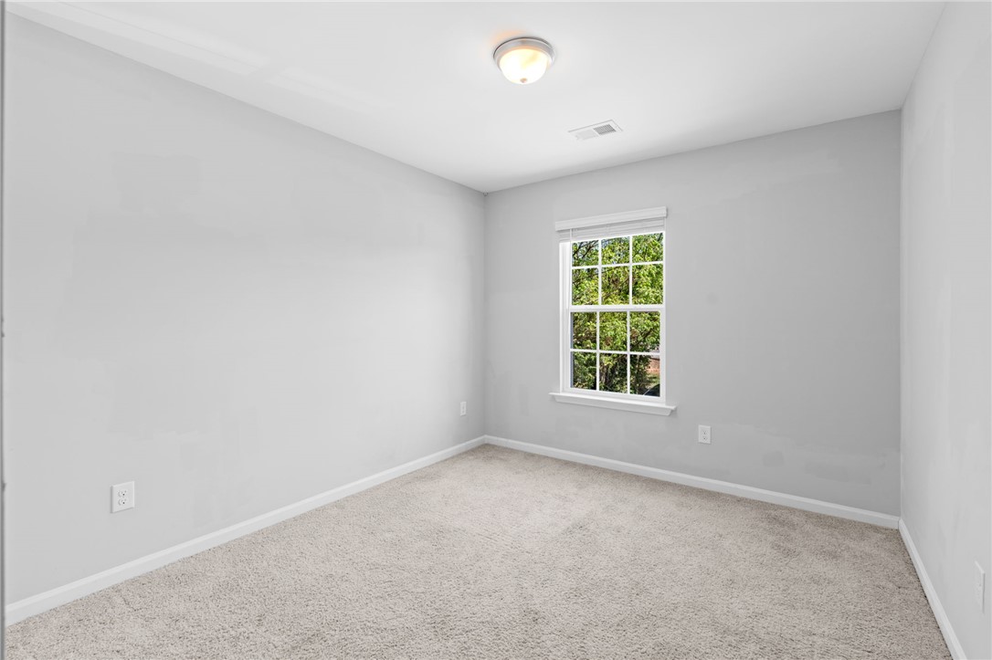 1237 Madden Bridge Road Central, SC 29630 - Photo 36 of 46 This bright bedroom features a window overlooking lush trees, creating a serene and private atmosphere.