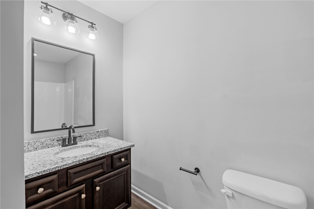 1237 Madden Bridge Road Central, SC 29630 - Photo 37 of 46 This bathroom features a sleek vanity, an elegant mirror, and a toilet, offering modern comfort and style.