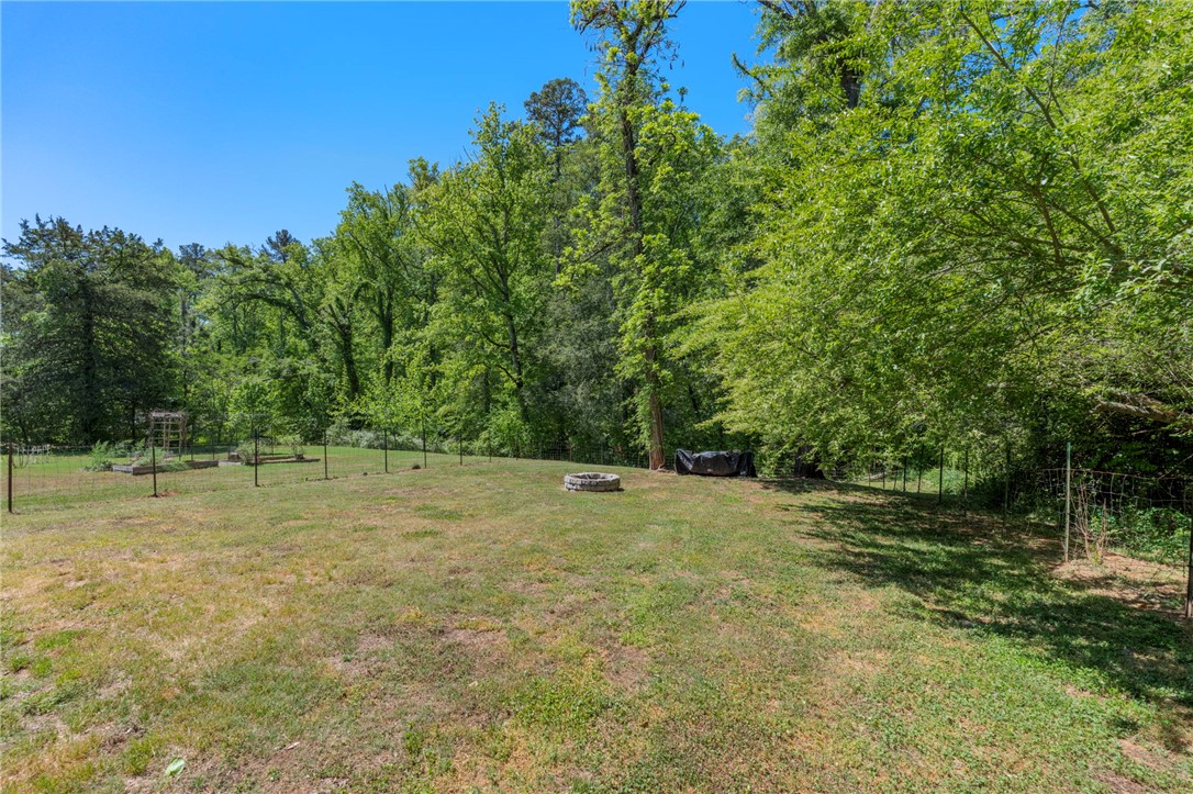 1237 Madden Bridge Road Central, SC 29630 - Photo 38 of 46 This lush yard features a charming fire pit, offering a tranquil retreat amidst abundant greenery.