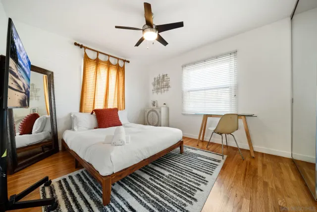 a bedroom with a bed and wooden floor