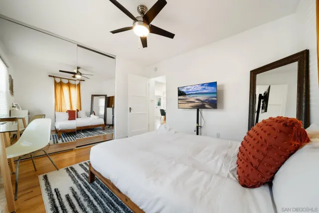 a bedroom with a large bed and a chandelier