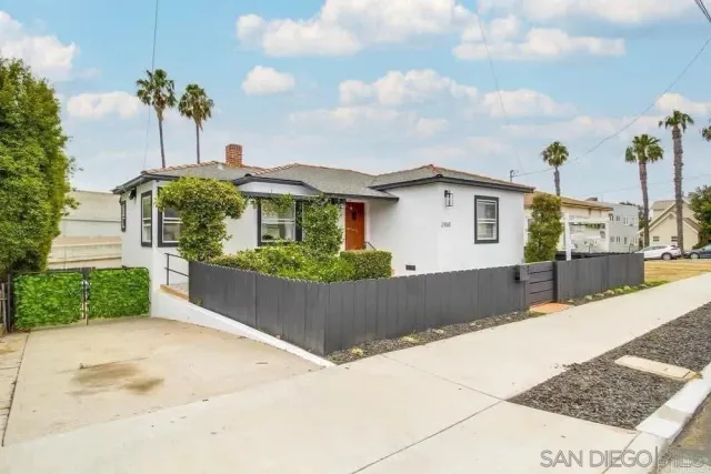 a front view of a house with a garden and trees
