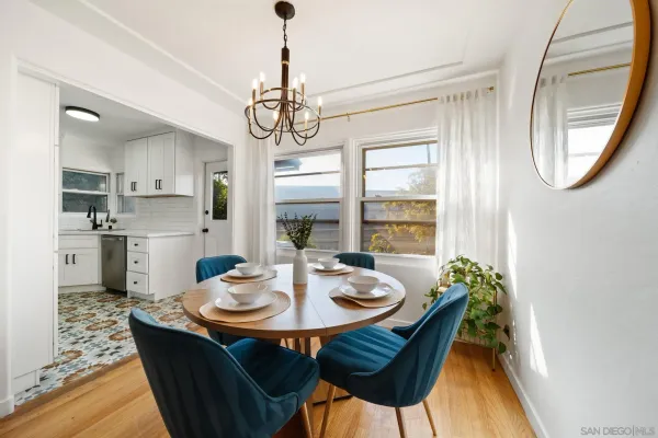 a outdoor dining room with furniture a chandelier and wooden floor