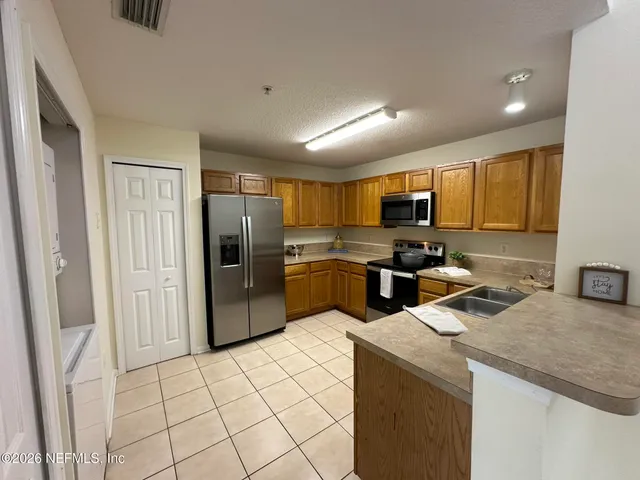a kitchen with granite countertop a refrigerator and a sink