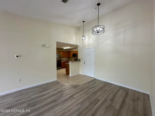 a view of a room with wooden floor and ceiling fan