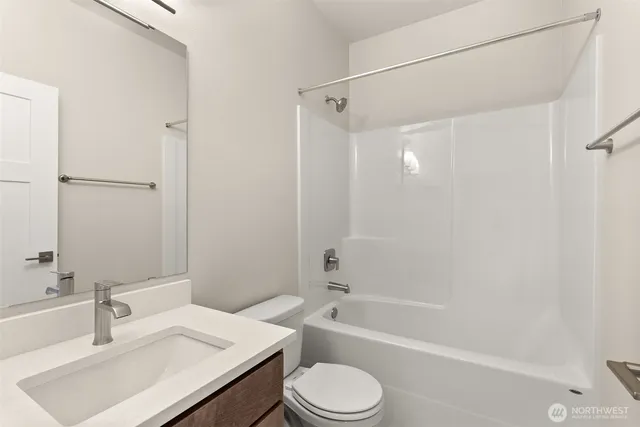 a bathroom with a sink toilet vanity and shower