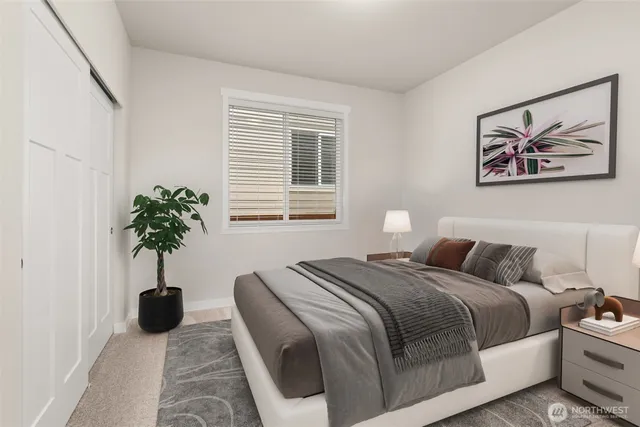 a bedroom with a bed and a potted plant