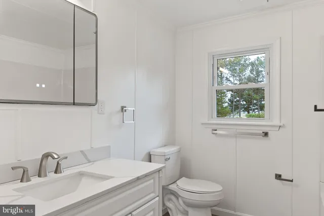 a bathroom with a sink a toilet and a window
