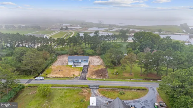 an aerial view of residential houses with outdoor space and ocean view