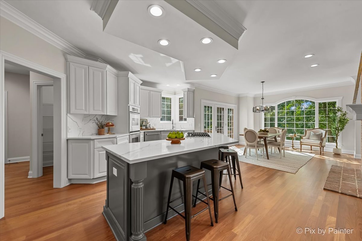 39W599 Walt Whitman Road St. Charles, IL 60175 - Photo 17 of 74 a kitchen with stainless steel appliances granite countertop a stove a refrigerator a kitchen island a dining table and chairs with wooden floor