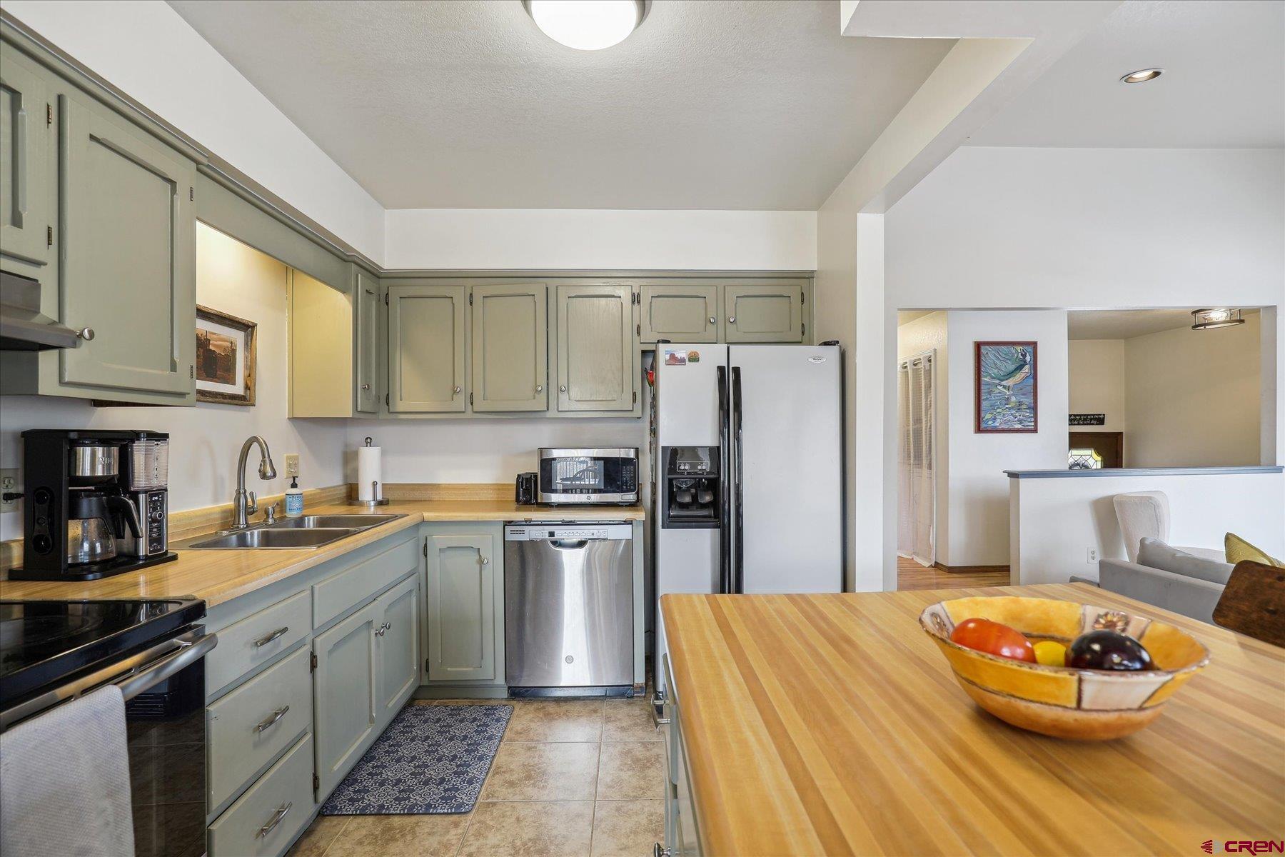 202 Pine Ridge Loop Durango, CO 81301 - Photo 11 of 33 a kitchen with stainless steel appliances granite countertop a refrigerator a sink dishwasher a stove with white cabinets and wooden floor