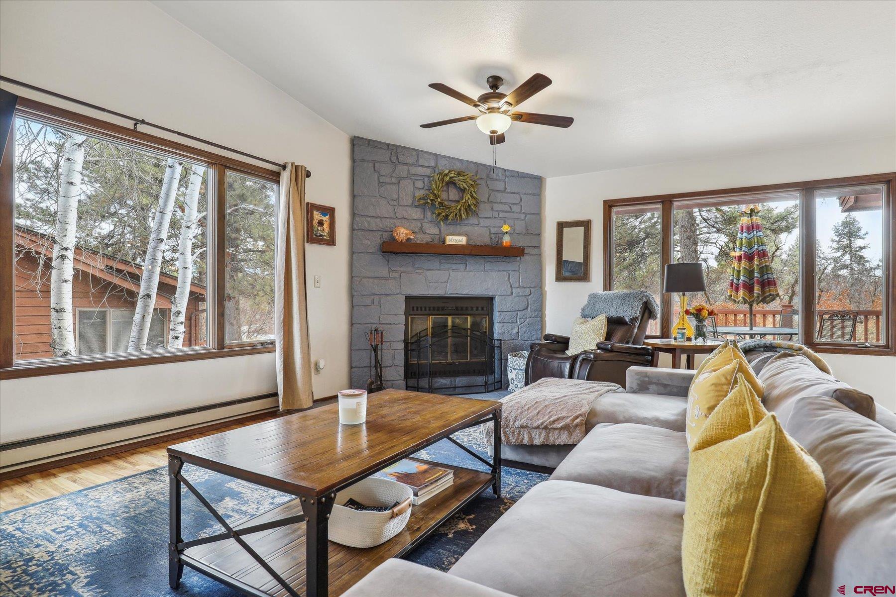 202 Pine Ridge Loop Durango, CO 81301 - Photo 5 of 33 a living room with furniture a floor to ceiling windows and a fireplace
