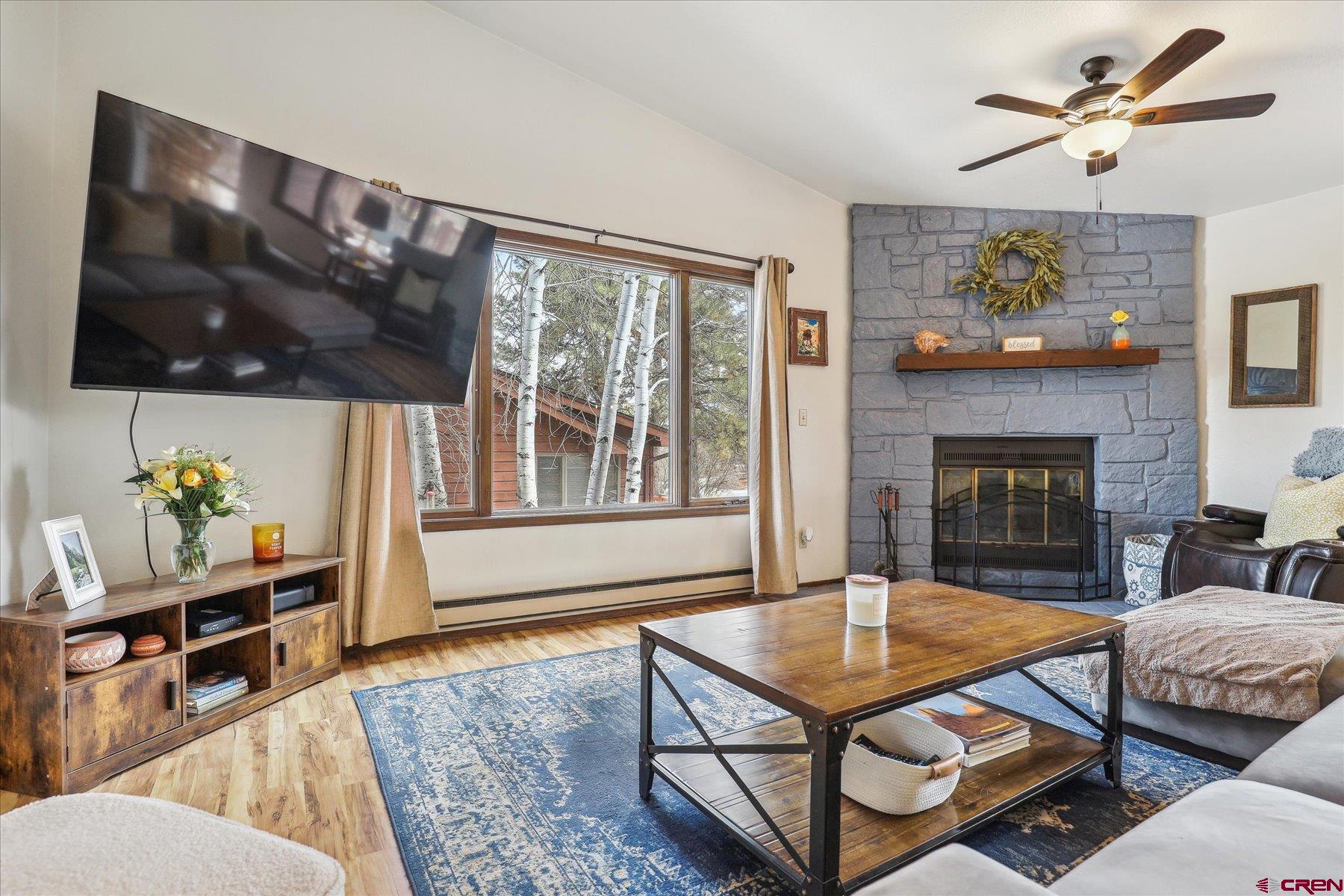202 Pine Ridge Loop Durango, CO 81301 - Photo 6 of 33 a living room with furniture a flat screen tv and a fireplace