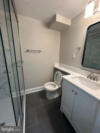 a bathroom with a sink a toilet and a mirror