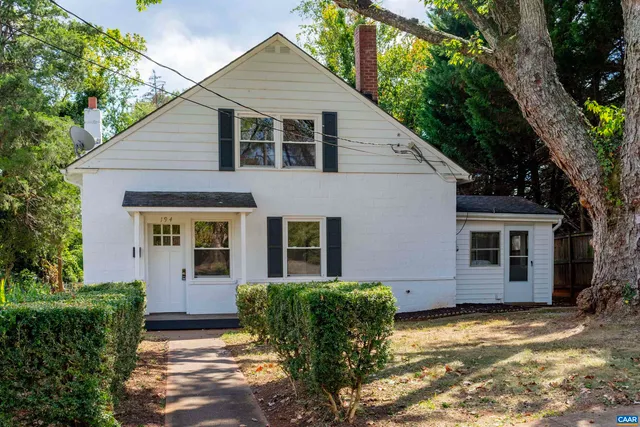 a backyard of a house with barbeque oven and a tree