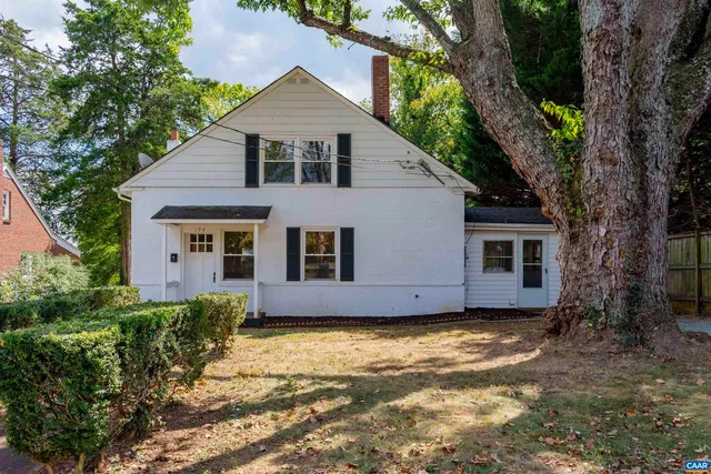 a view of a house with a tree in front of it