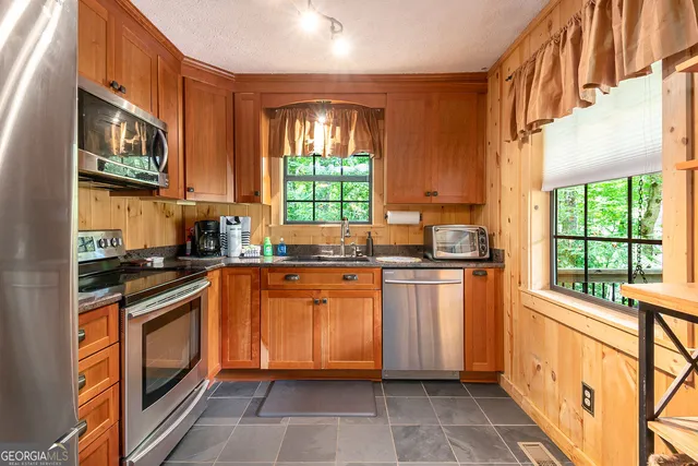 a kitchen with stainless steel appliances granite countertop a stove a sink and a microwave