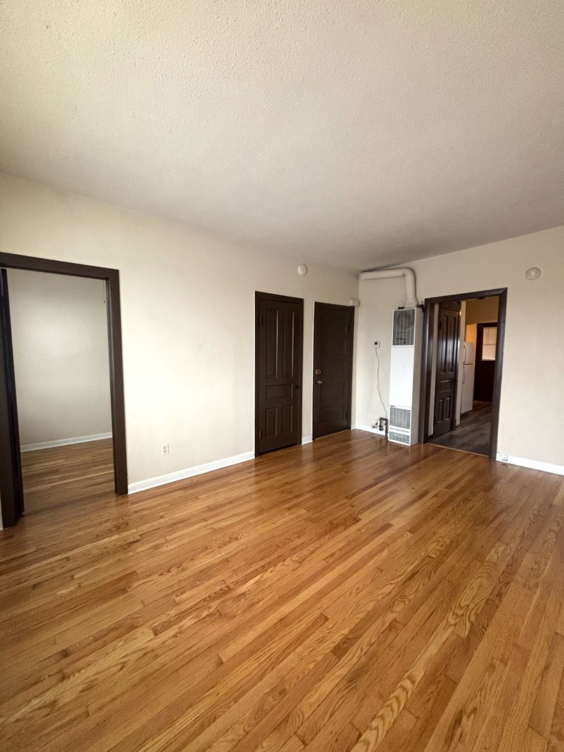 3003 North Ashland Avenue, Unit 3 Chicago, IL 60657 - Photo 5 of 14 a view of an empty room with wooden floor and window