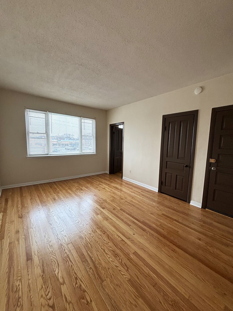3003 North Ashland Avenue, Unit 3 Chicago, IL 60657 - Photo 6 of 14 a view of an empty room with wooden floor and a window