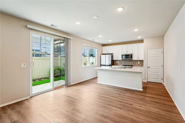 a view of kitchen with kitchen island wooden floor window and refrigerator