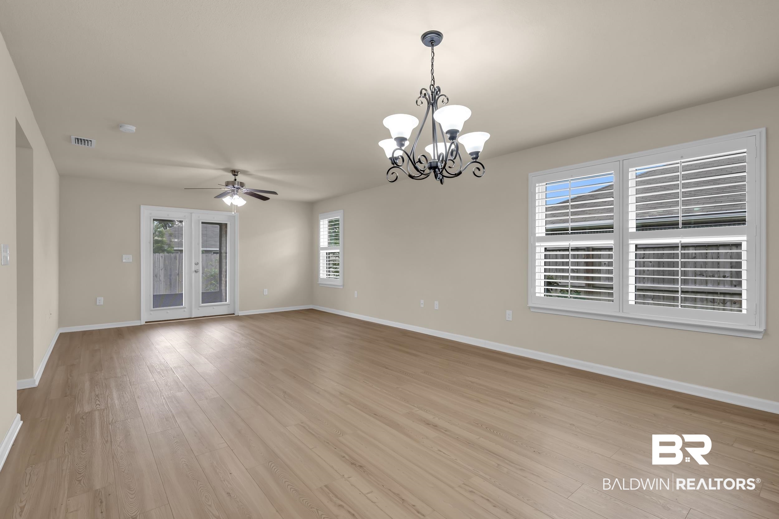 1704 Abbey Loop Foley, AL 36535 - Photo 15 of 38 Open-concept living area with light wood-finish flooring, neutral wall tones, and white trim