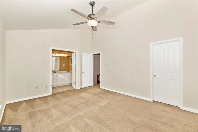 an empty room with a ceiling fan and a window