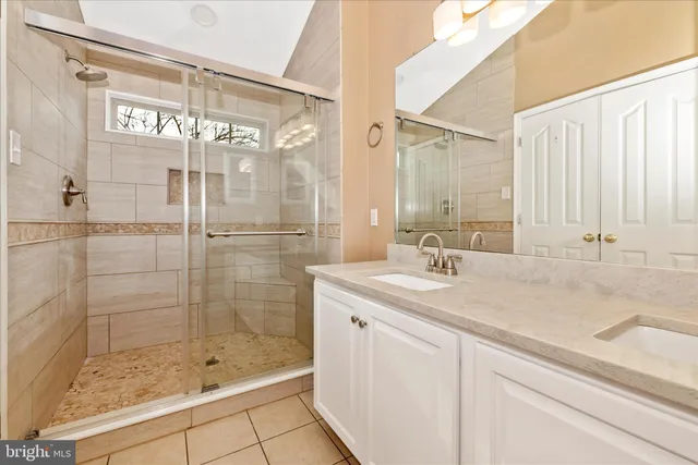 a bathroom with a shower and a sink a mirror