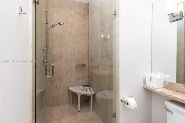 a bathroom with a granite countertop sink a toilet and shower